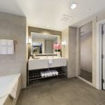 Large walking bathroom with tub with single person sink and separate toilet area at The Hotel at Arundel Preserve