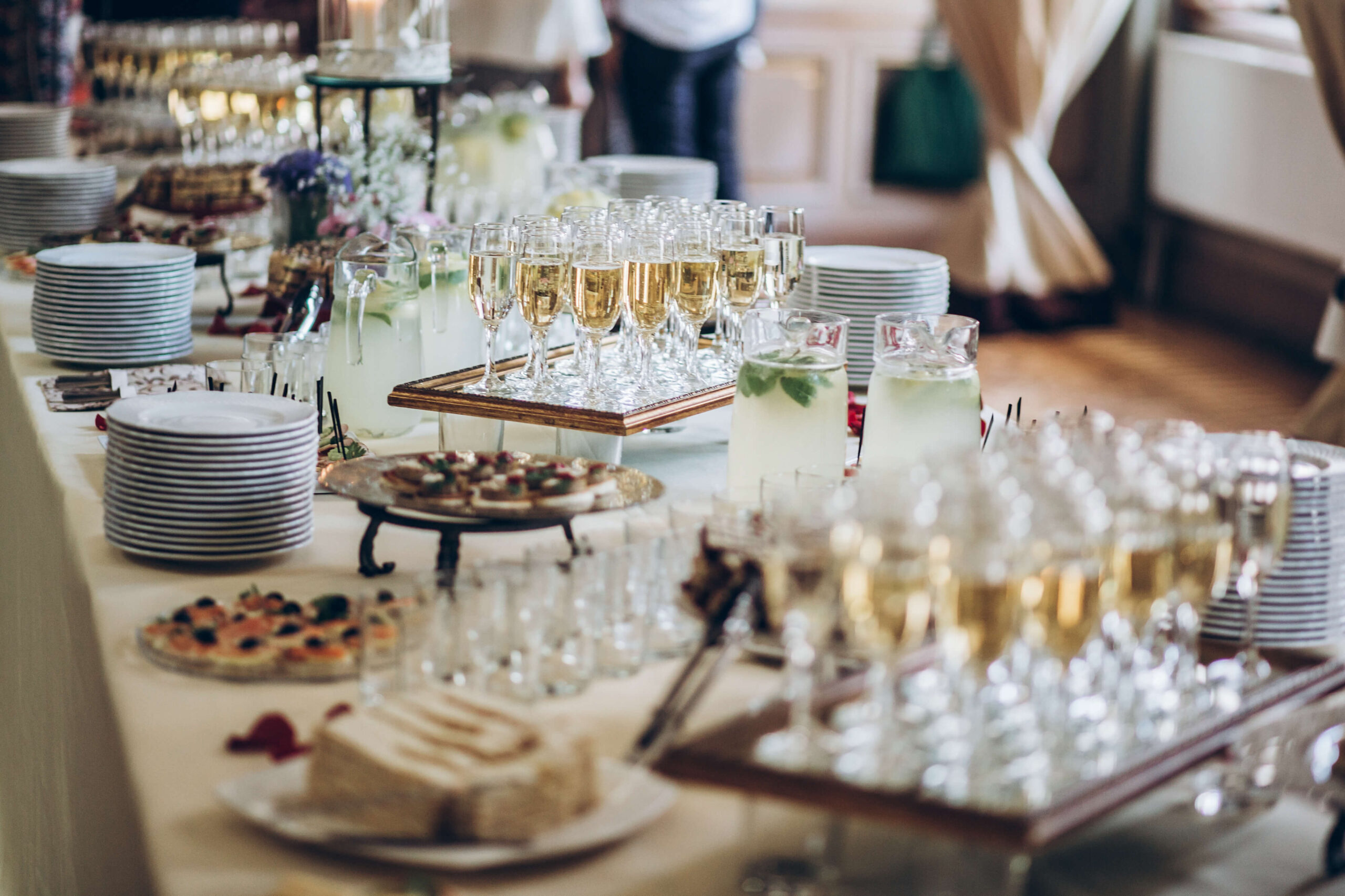 stylish champagne glasses and food appetizers on table at wedding reception
