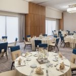 Large room with multiple tables and chairs set up for dinning